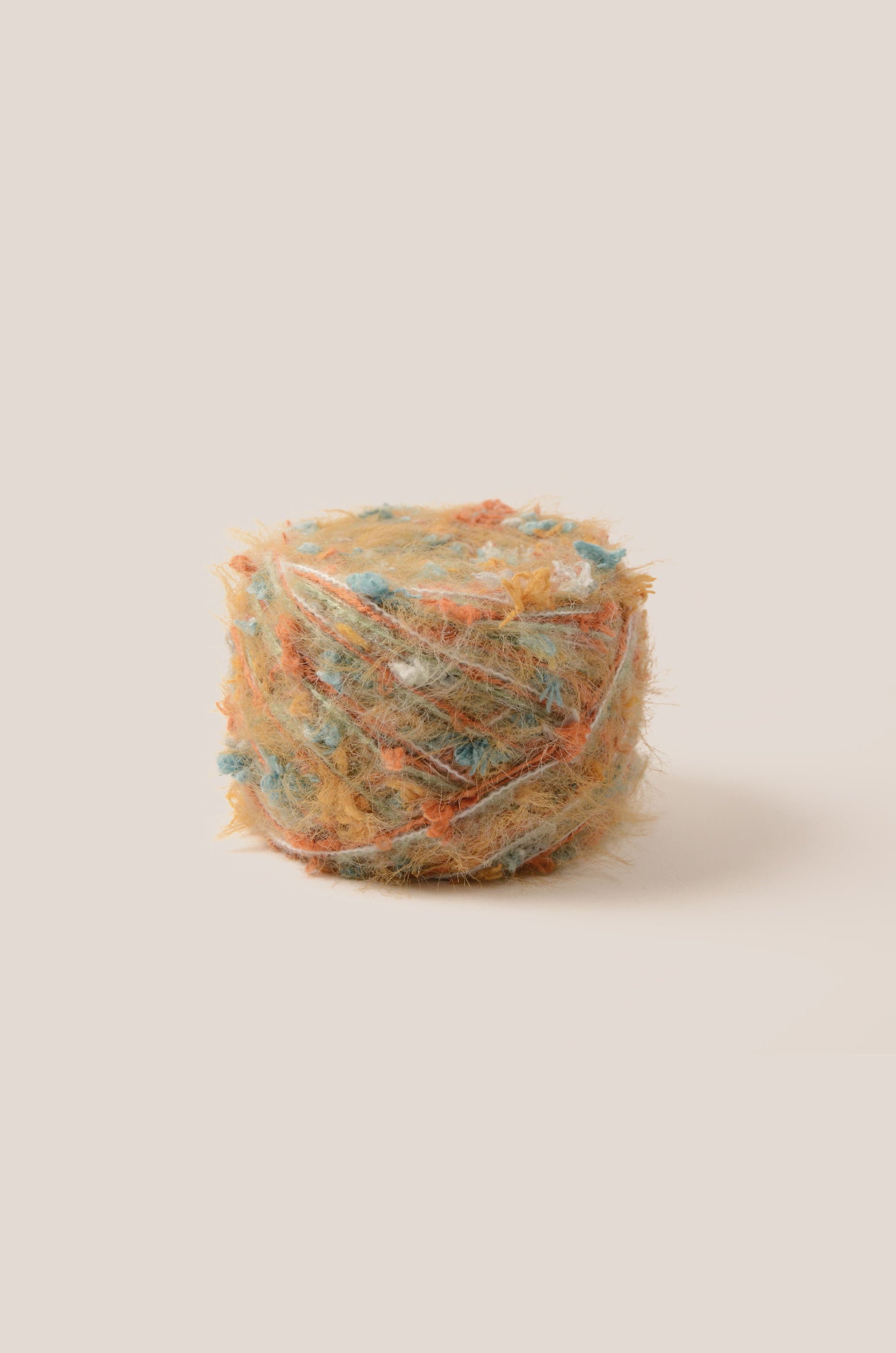 Amber Dunes hand-blended yarn – sunset orange base with misty blue and white threads, soft texture inspired by desert cliffs and sunset tones