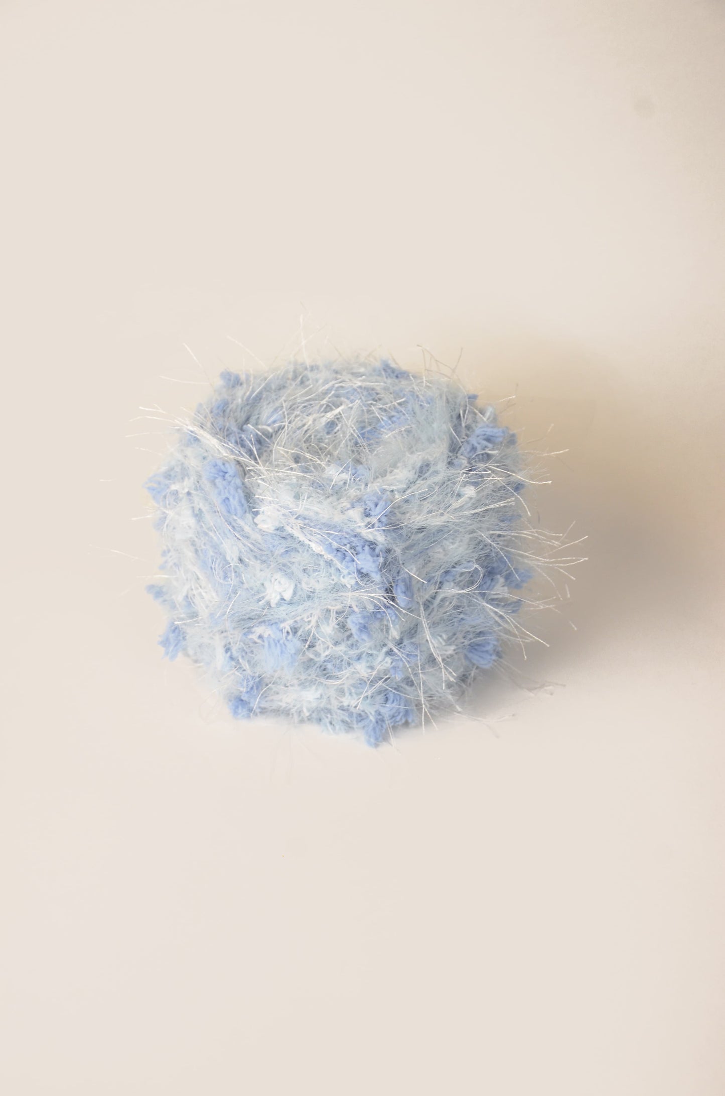 Cirrus Sky hand-blended yarn – light blue base with white dancing fibres and sky-blue threads, fluffy texture inspired by clouds and ocean air