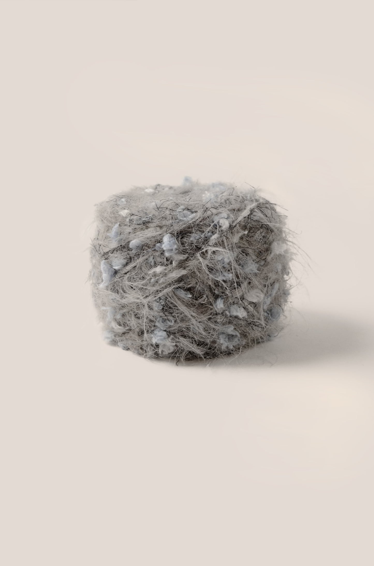 Graphite Shadow hand-blended yarn – smoky grey base with mist blue threads and soft fluffy fibres, inspired by ocean mist and natural shadows