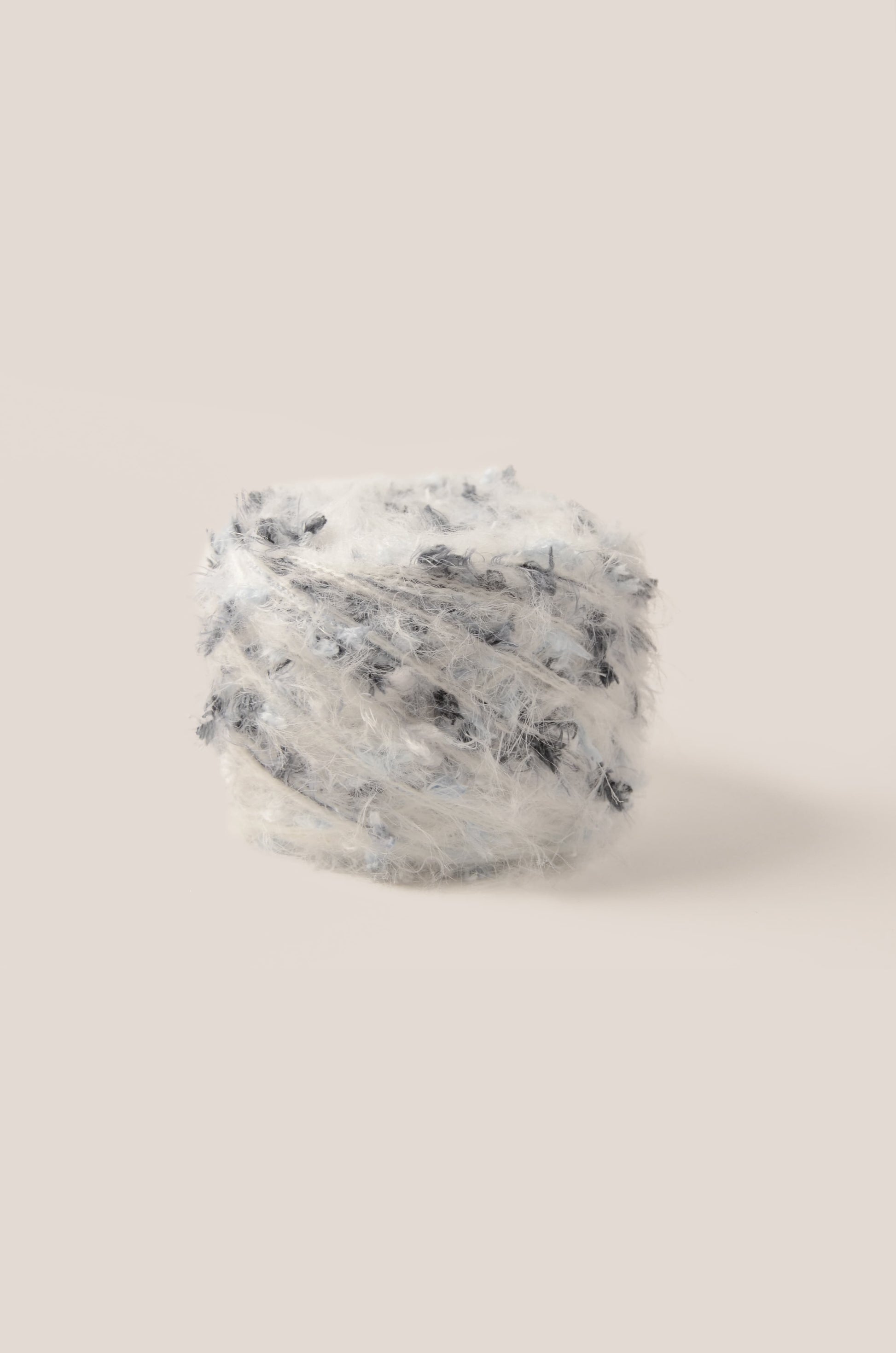 Marble Cloud hand-blended yarn – soft white base with smoke black and pale blue threads, fluffy texture inspired by ocean mist and natural calm