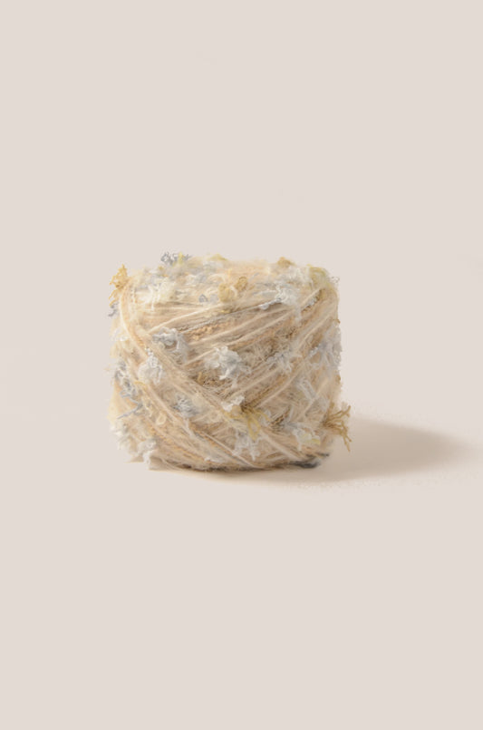 Santorini hand-blended yarn – warm cream base with soft sky-blue and pale yellow threads, smooth cosy texture inspired by sand and coastal tones