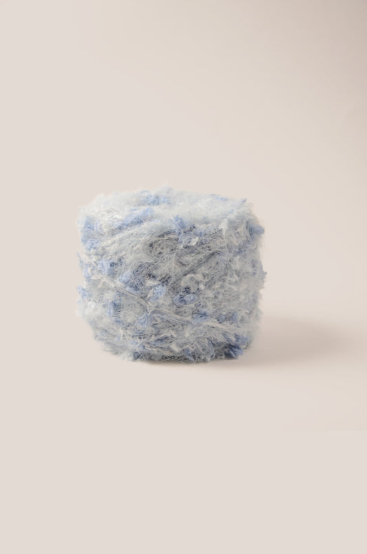 Sky Mist hand-blended yarn – pale blue base with ocean blue threads, fluffy texture inspired by misty morning light over calm sea