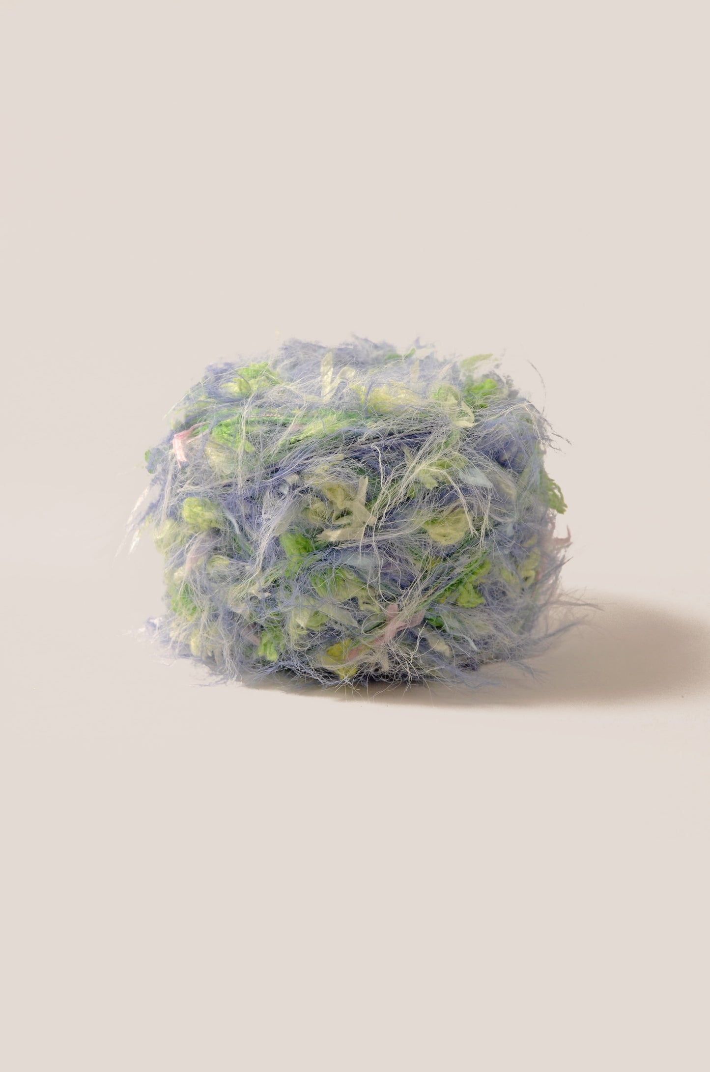 Spring Bouquet hand-blended yarn – cornflower blue base with green and pink threads, soft fluffy texture inspired by spring wild flowers