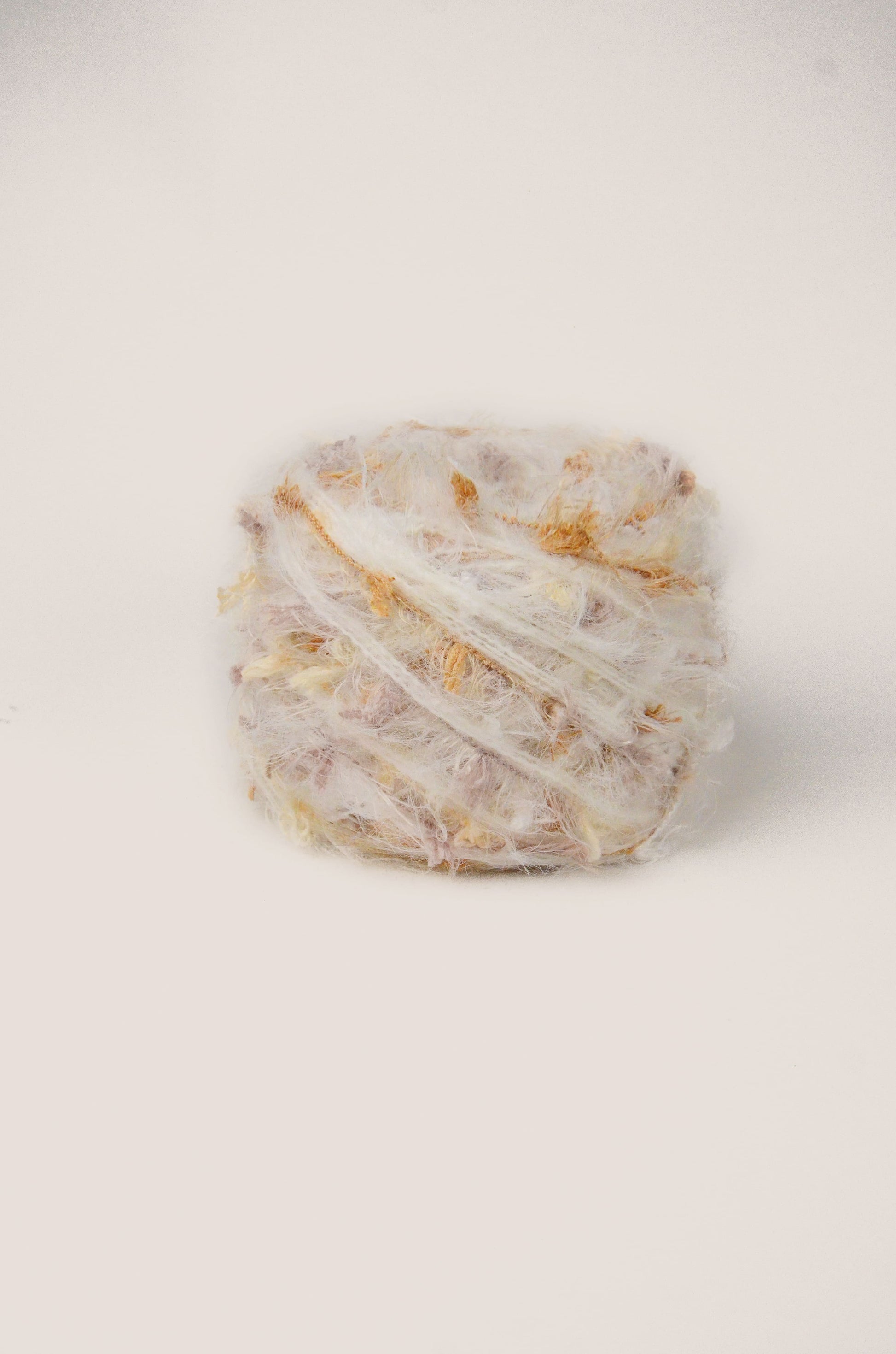 Vanilla Soufflé hand-blended yarn – cream white base with soft beige and lilac threads, fluffy texture inspired by the gentle warmth of the earth